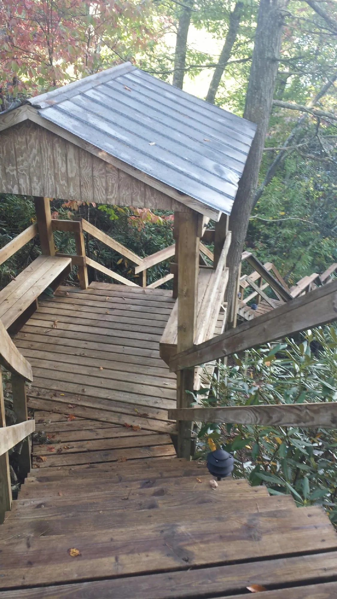 Metal roofed shelter over wooden steps on a wooded walkway — Skylight Repair & Installation work by our crew in Essex